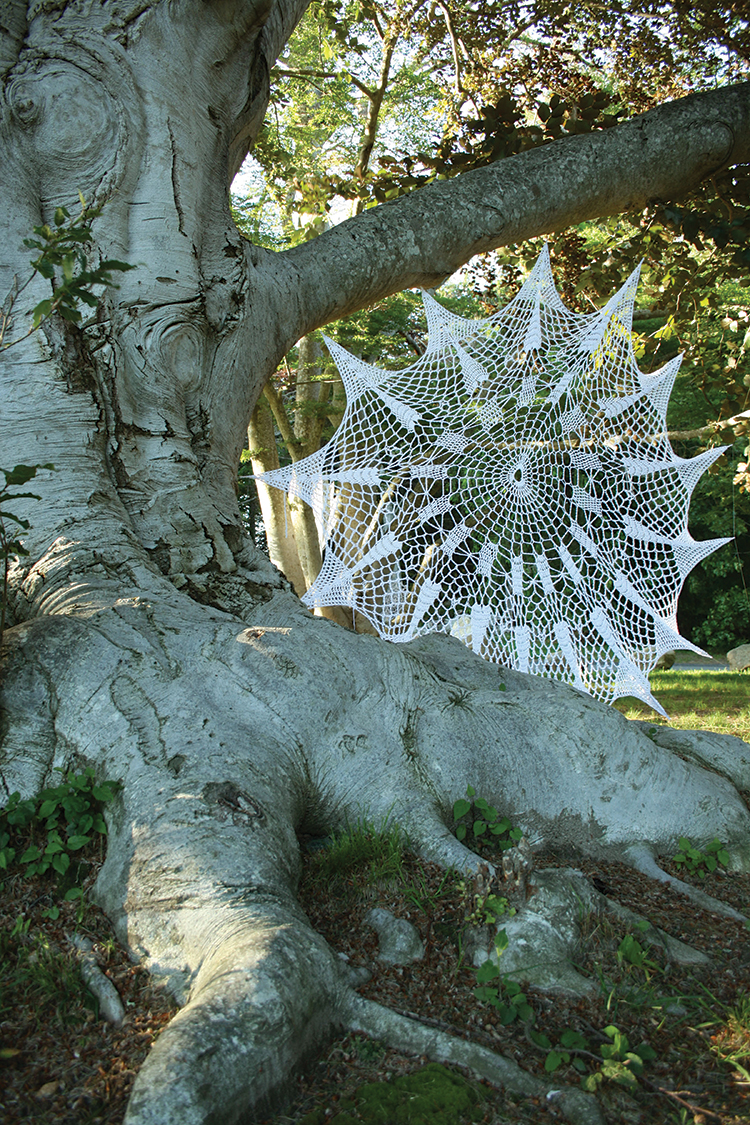 This is an image of Queen Anne's Lace installed at Edith Wharton's Home, The Mount, in Lenox, MA in 2019. The white doilies are made at home with nylon yarn and tied into the trees along a path. There were 13 doilies as part of this installation.